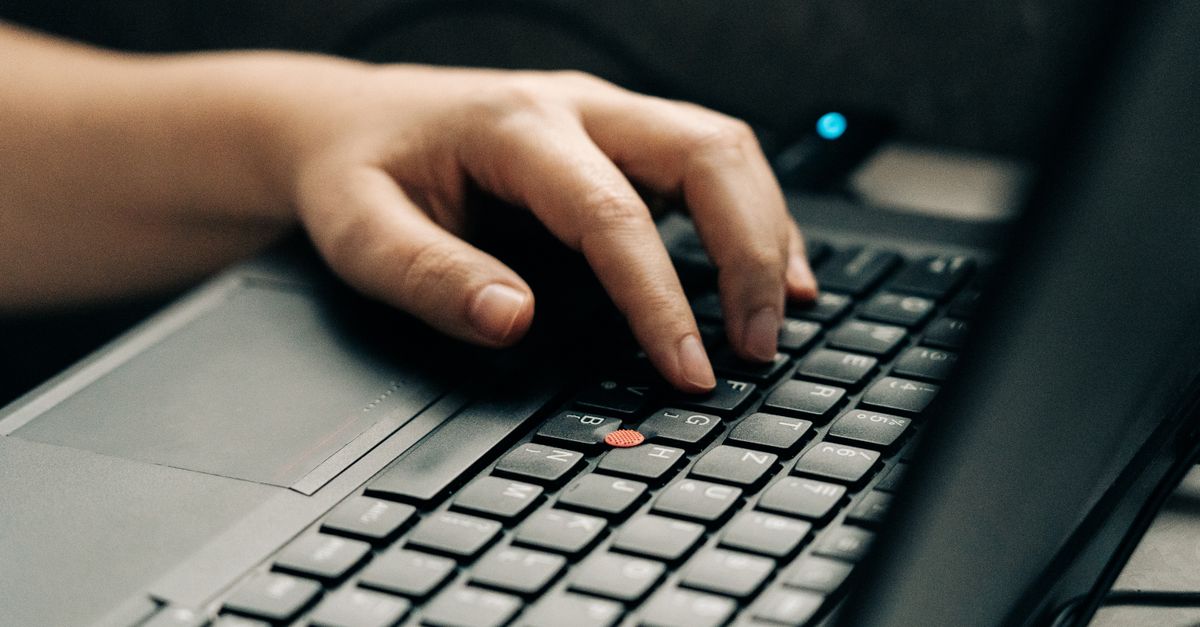 Close-up of hands typing a fix on a laptop keyboard, addressing the Cisco FMC vulnerability