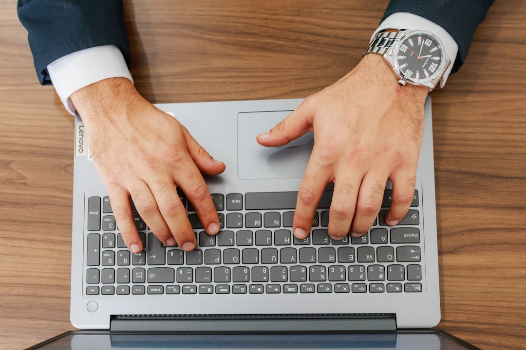 IT manager typing on a laptop keyboard while checking servers for the SharePoint zero-day vulnerability