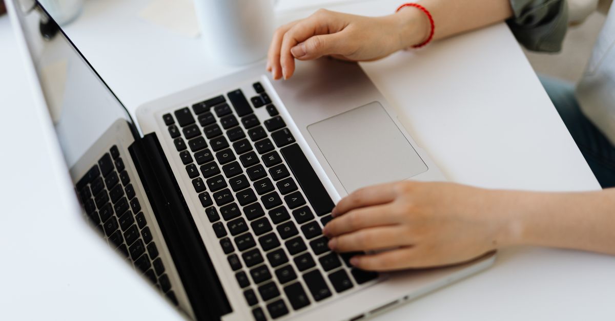 IT professional working at a laptop, checking systems for signs of compromise