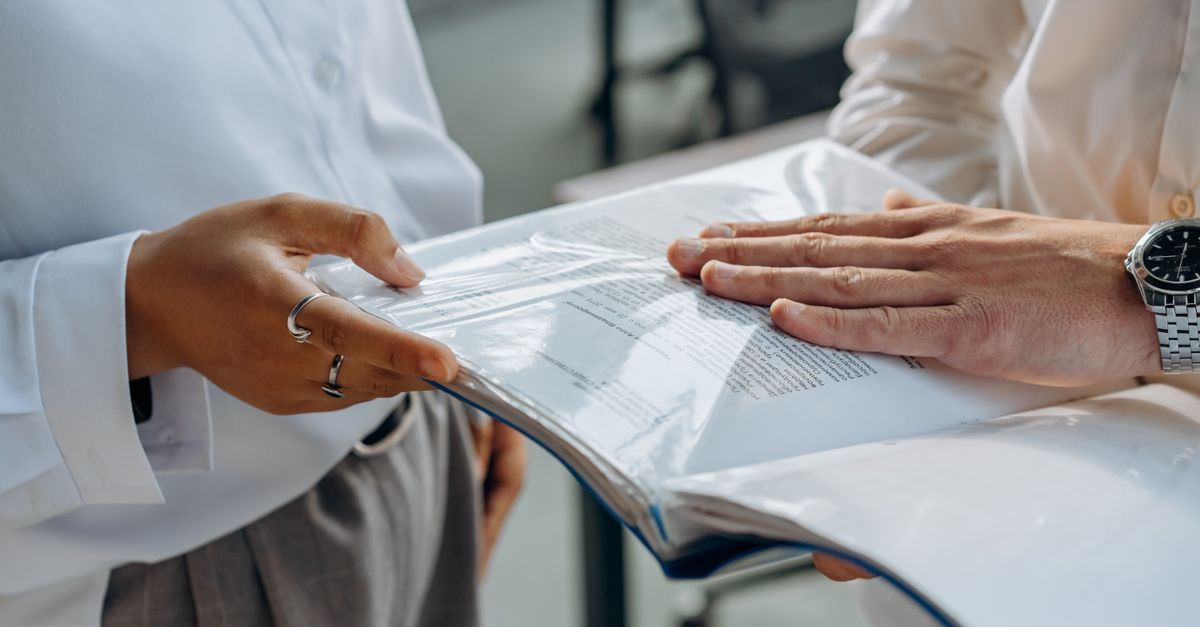 Two colleagues reviewing penetration test findings and compliance documentation together