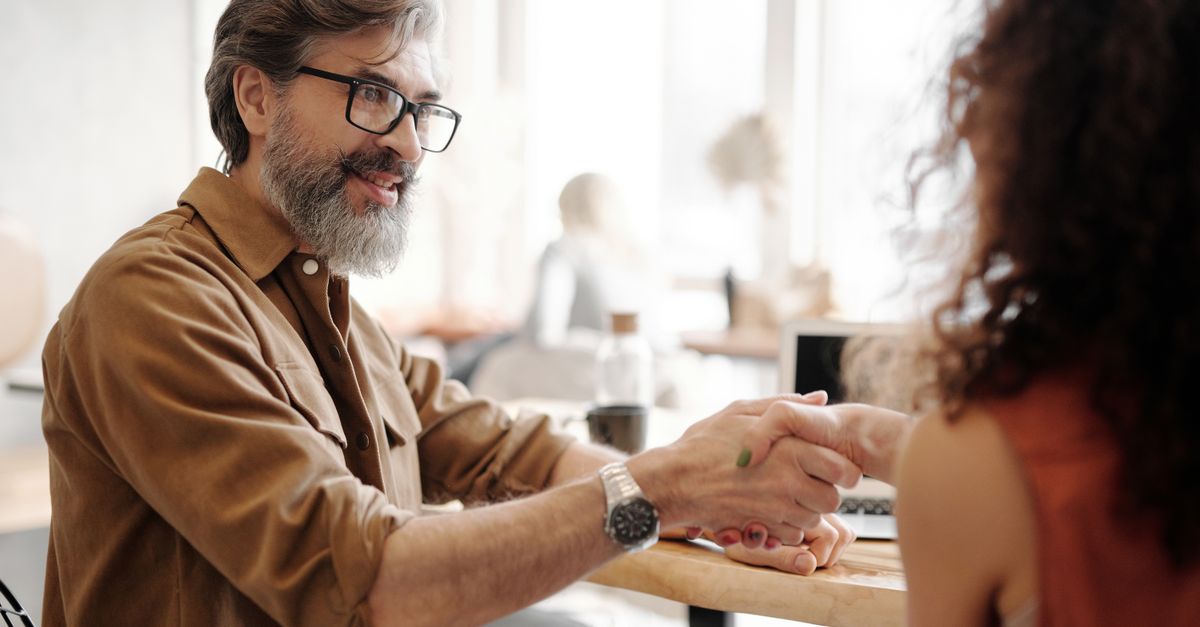 A business owner shaking hands with a penetration testing company representative after agreeing terms