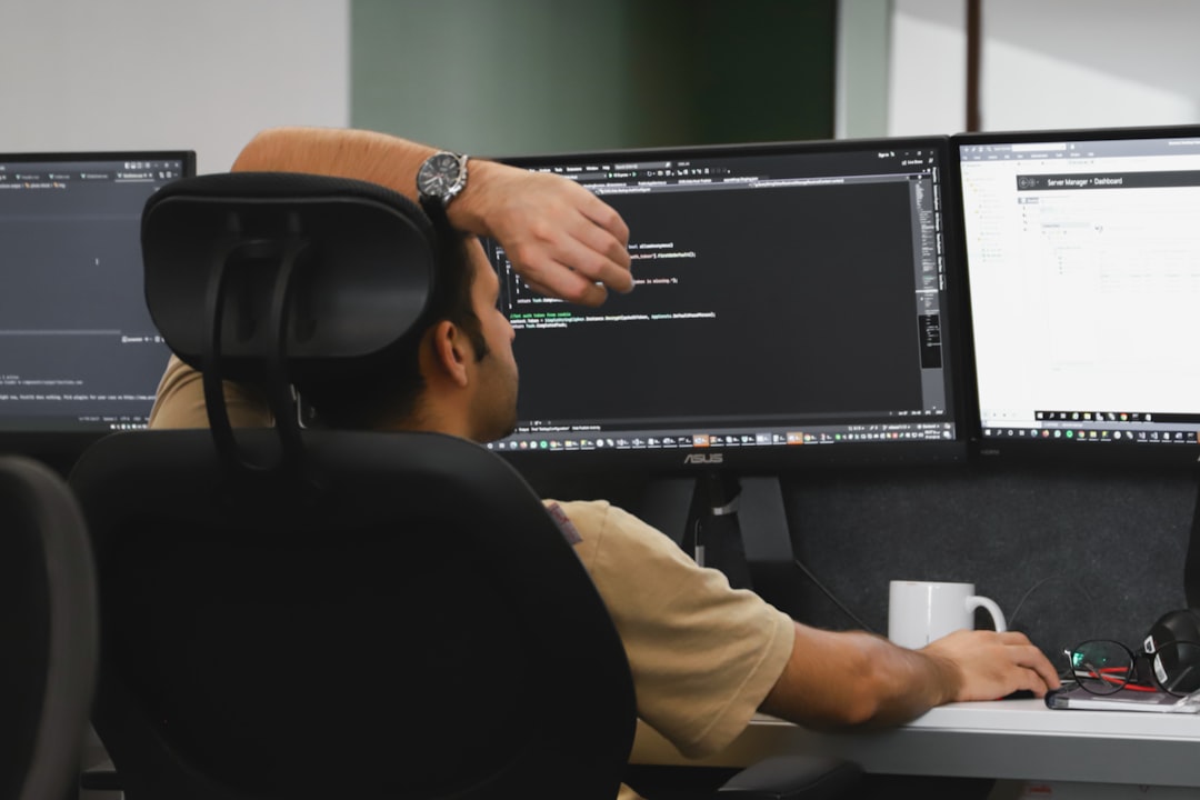 A person reviewing a server management dashboard on dual monitors, the kind of check needed after the WordPress XSS vulnerability disclosure