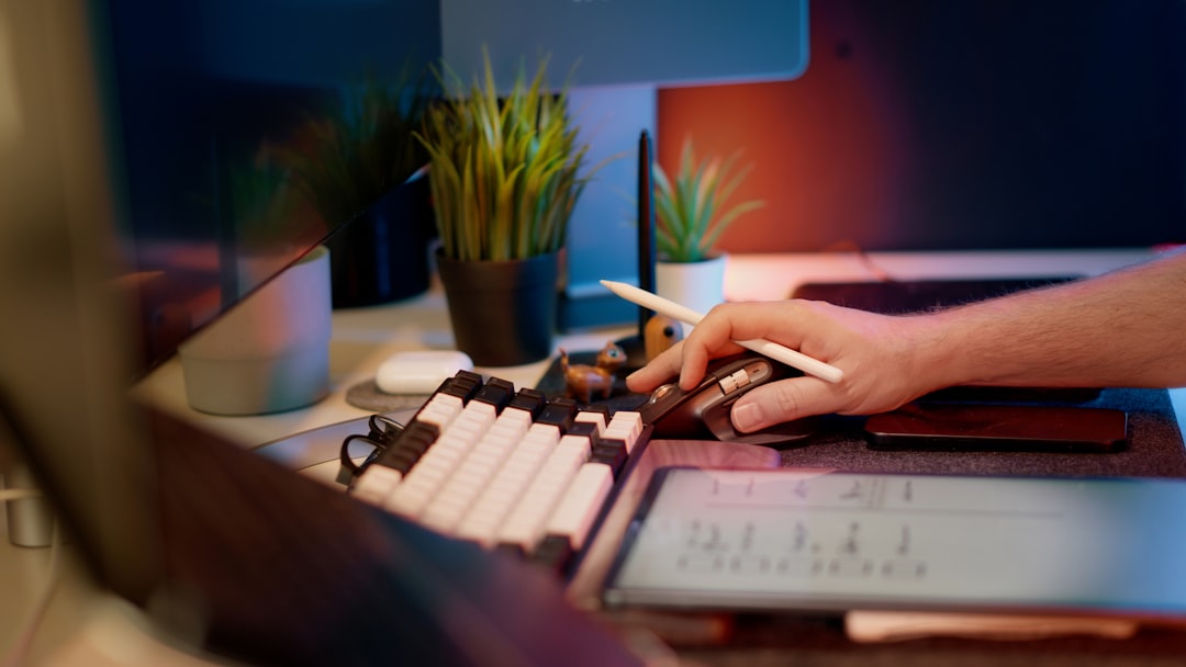 Close-up of a hand on a computer mouse beside a keyboard, reviewing logs for signs of the N-central vulnerability