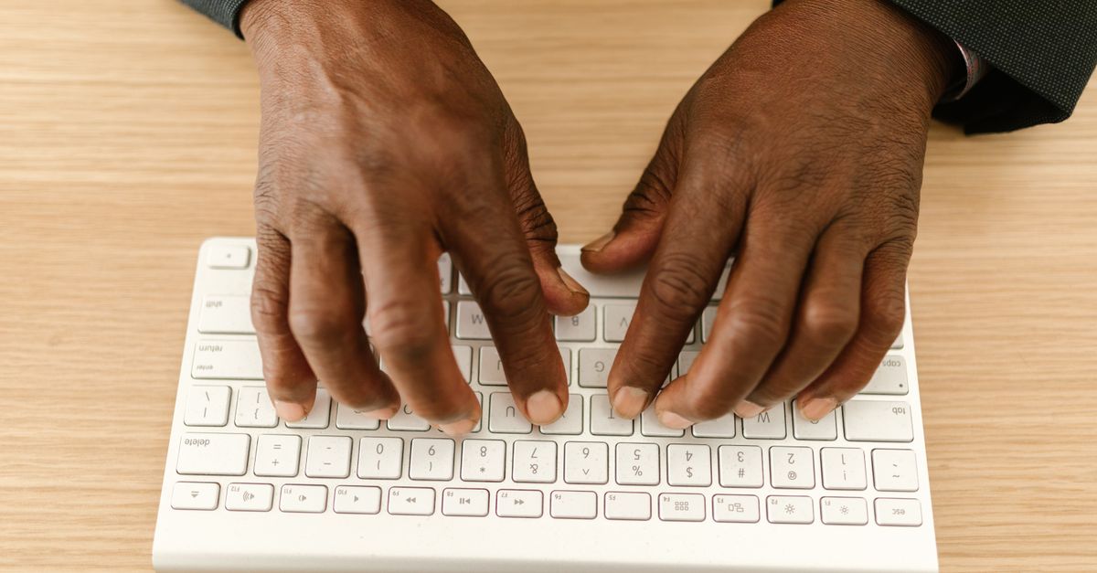 Close-up of hands typing on a keyboard while checking a website for critical WordPress plugin flaws