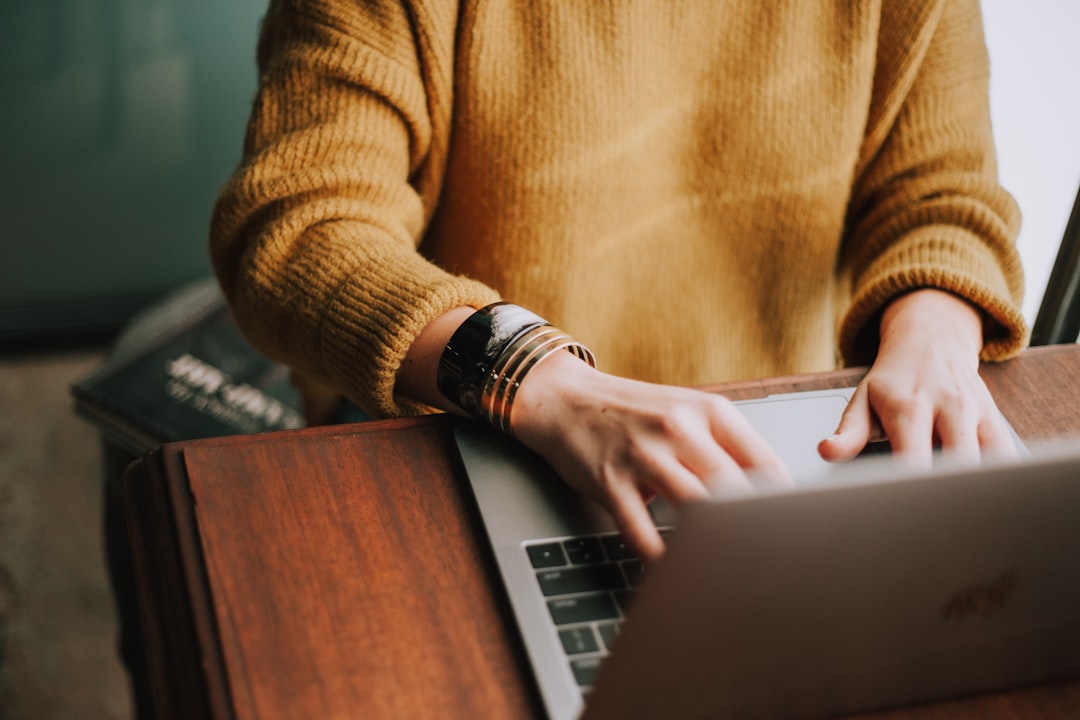 Close-up of hands typing on a laptop keyboard, illustrating guest access to an online customer portal