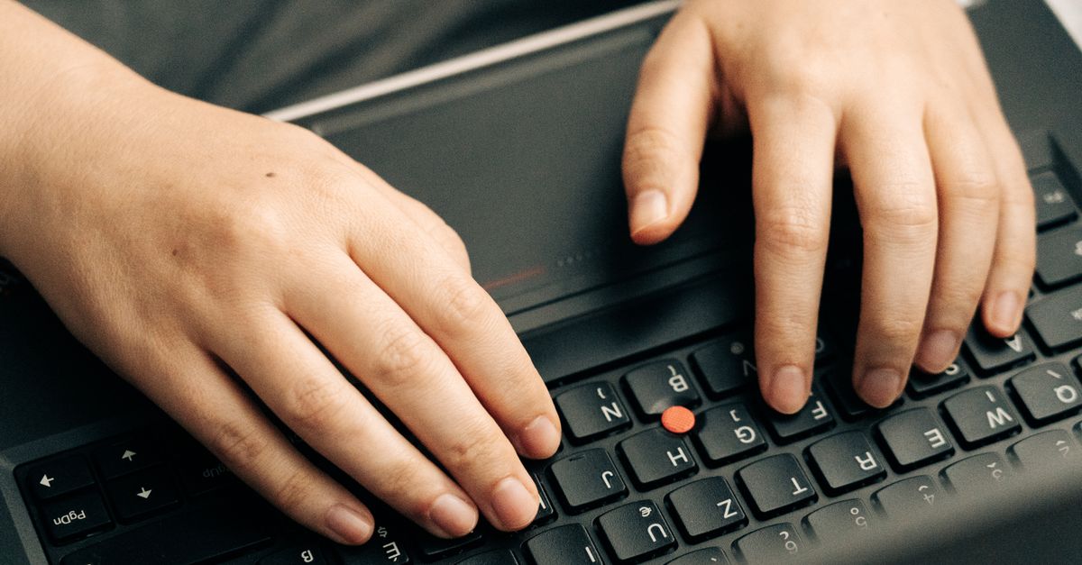 Close-up of hands typing on a laptop keyboard, representing the admin access exposed by the Metabase SQL injection vulnerability