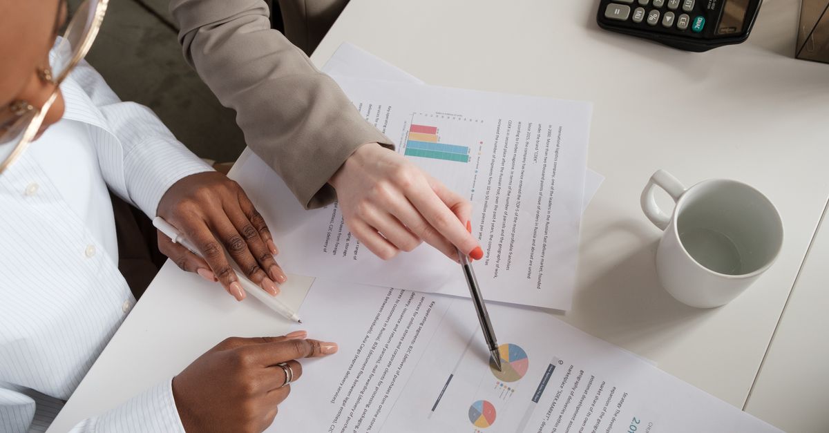 Two colleagues reviewing a security testing proposal with charts before signing