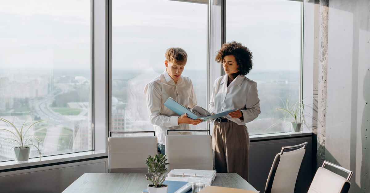 Two colleagues reviewing an access policy document together in an office