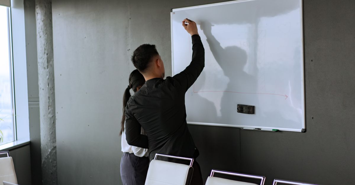 Two colleagues sketching out a phased zero trust security roadmap on a whiteboard