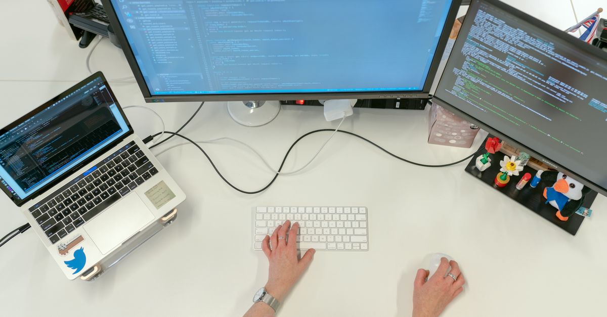 A developer's multi-monitor setup showing code editors during a software release