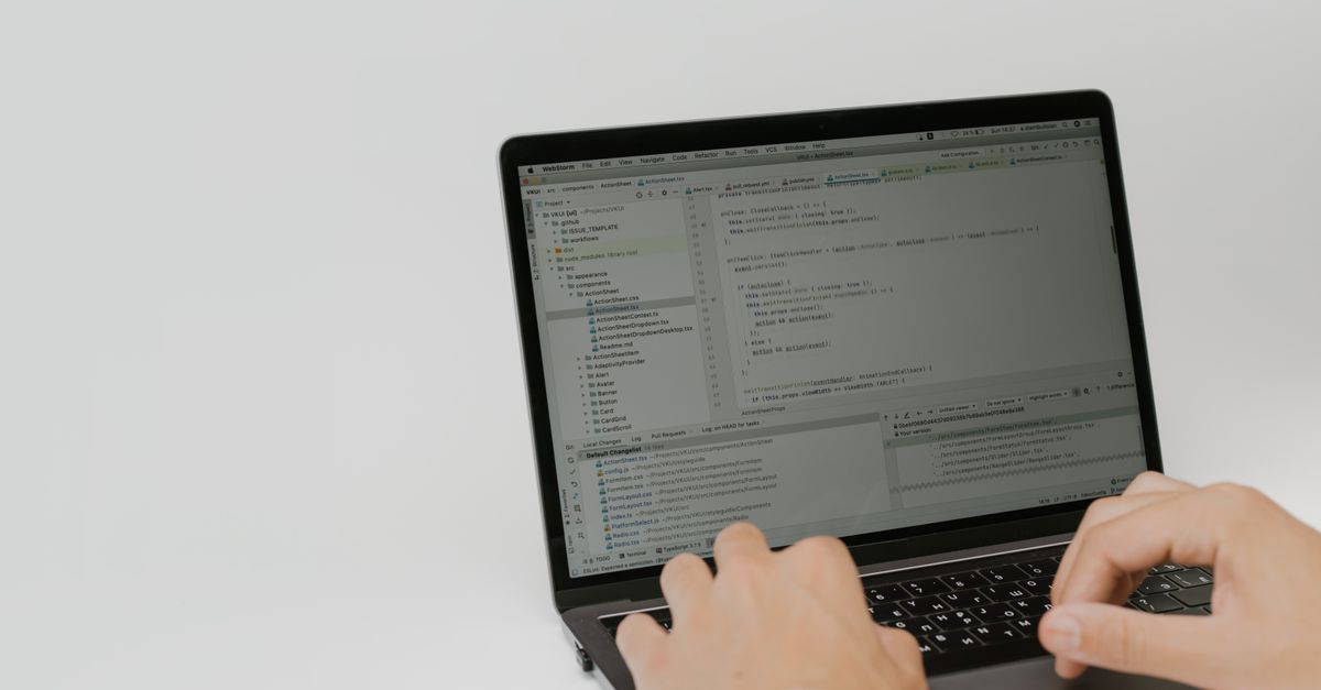Close-up of hands editing website code on a laptop, the kind of theme and plugin check the WordPress Click2Shell flaw calls for