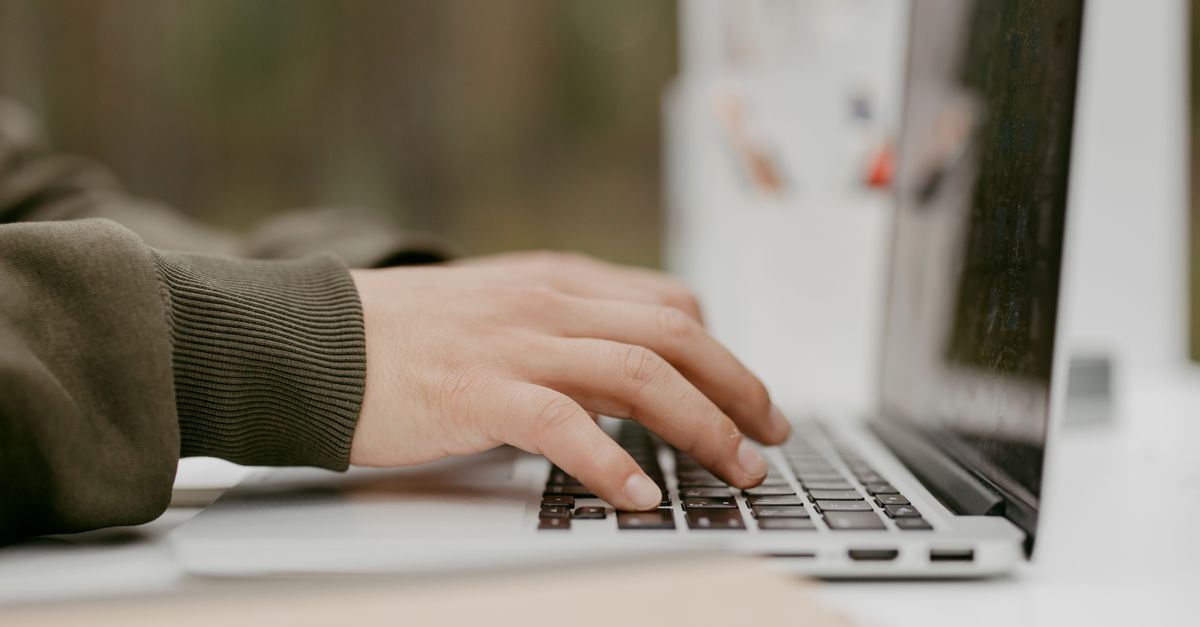 Close-up of hands typing on a laptop keyboard while patching a GitLab path traversal vulnerability