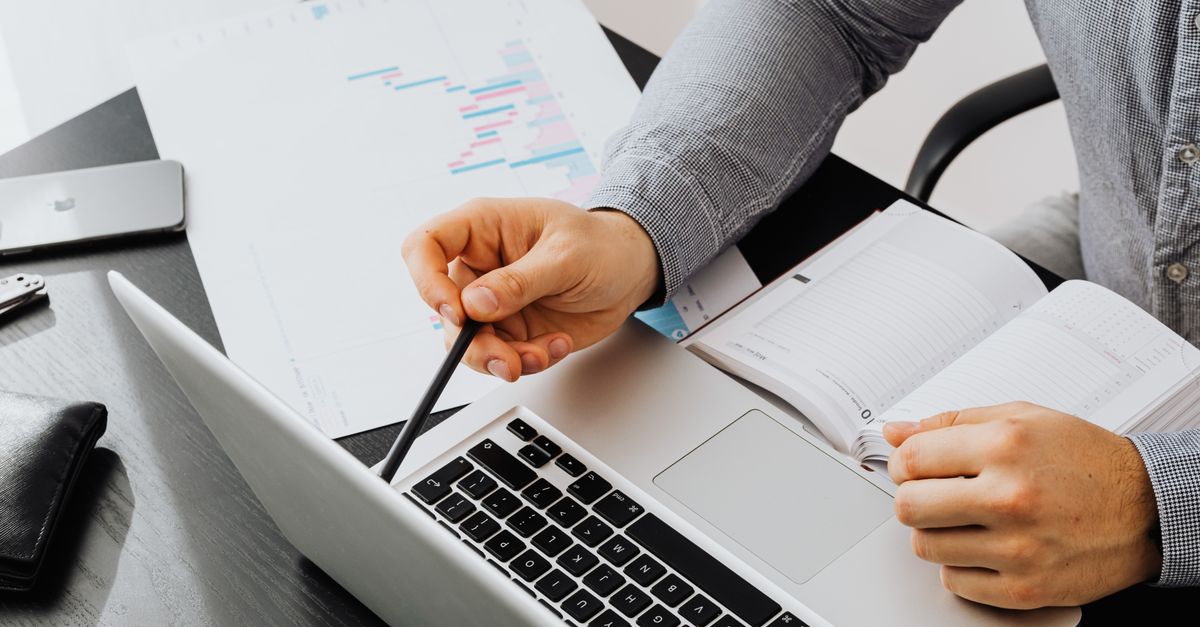 Consultant reviewing network segmentation testing findings against a project timeline on a laptop