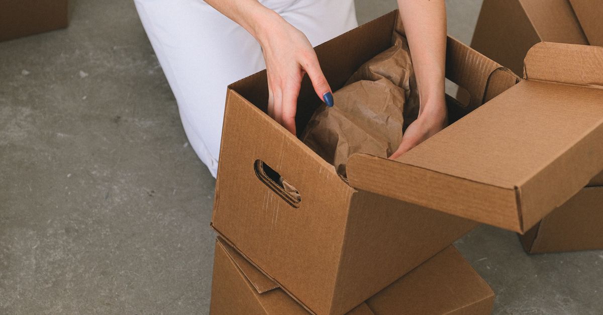 Hands packing an online order into a box, representing a store affected by the unpatched Magento vulnerability