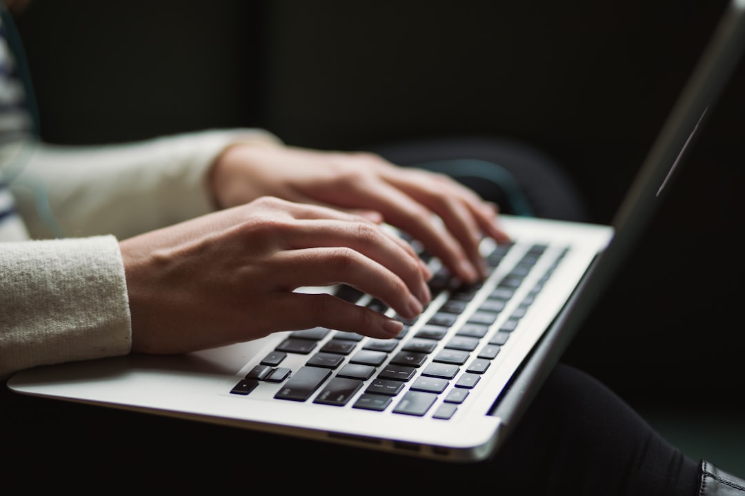 Hands typing on a laptop keyboard, reviewing case files after a third party data breach
