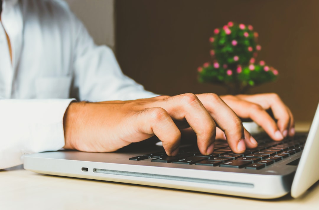 Hands typing on a laptop keyboard while running penetration testing for schools checks