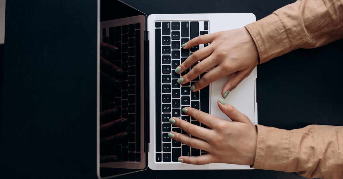 Hands typing on a laptop, the kind of admin access stolen in the Bitget hack