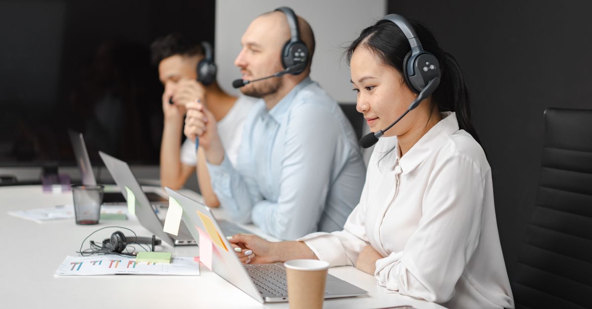 Help desk staff wearing headsets at their laptops, the identity impersonated in Microsoft 365 vishing attacks