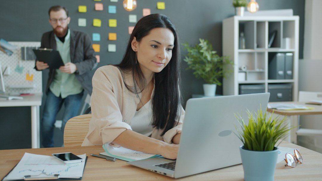 Office worker at a laptop, the kind of everyday system where a security misconfiguration hides