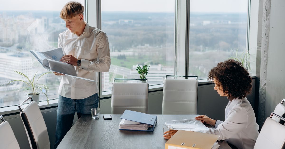 Two colleagues reviewing financial reports together, weighing the cost of a data breach UK businesses budget for