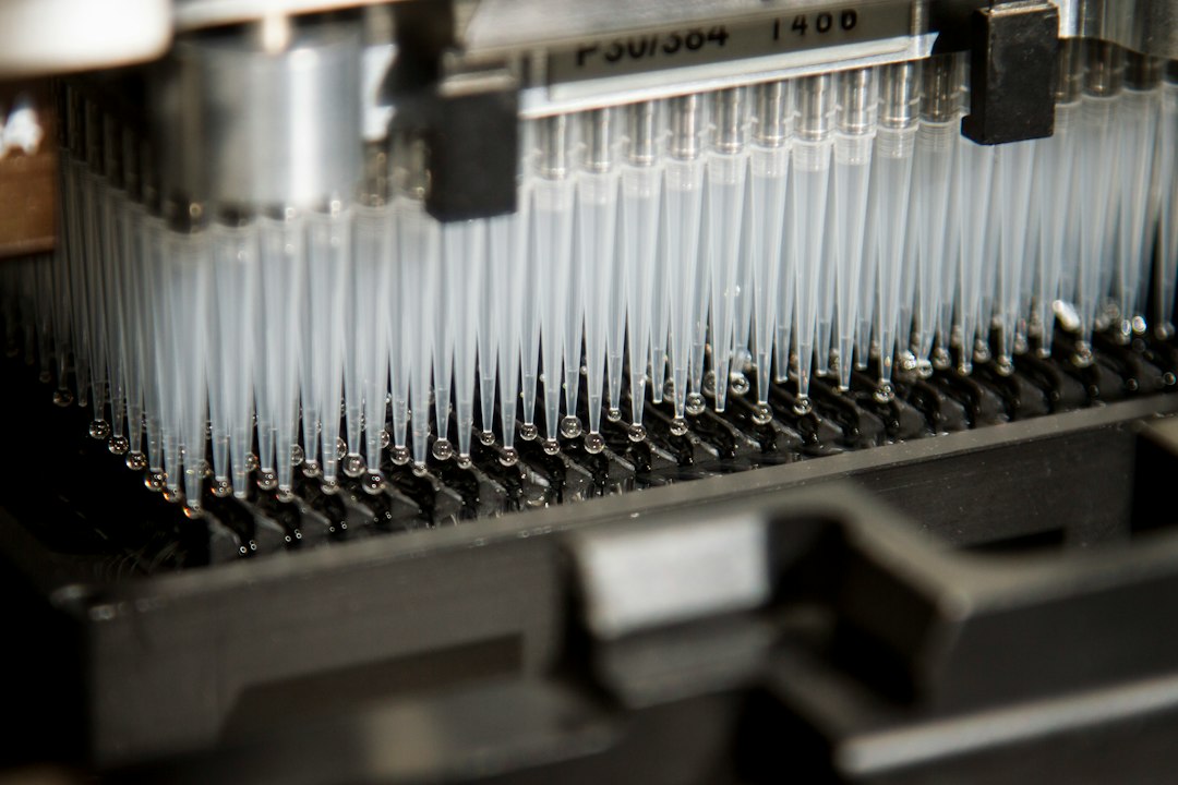Automated pipette tips at a laboratory analyser, the kind of testing a supplier outage halts after a Qilin ransomware arrest story