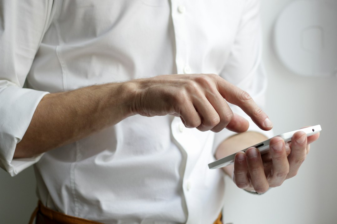 Hand tapping a phone screen, as customers did when the ASOS cyber incident alert arrived