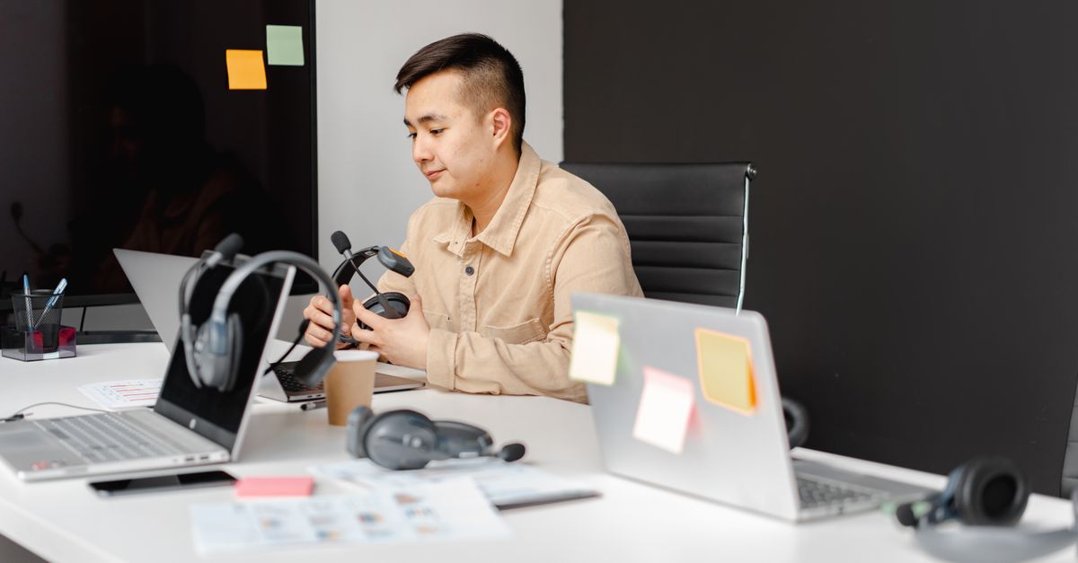 Help desk worker holding a headset, the first target of ShinyHunters style social engineering