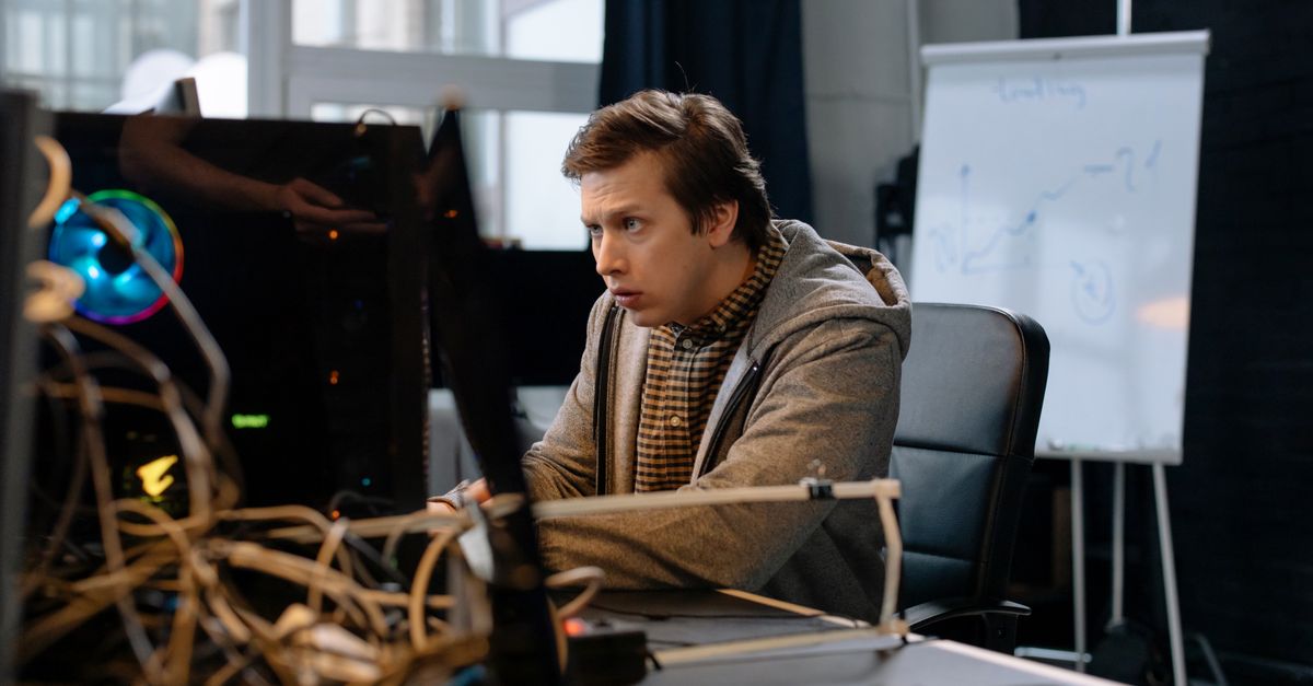 IT administrator looking worried at a screen beside tangled cabling while checking a NetScaler SAML vulnerability