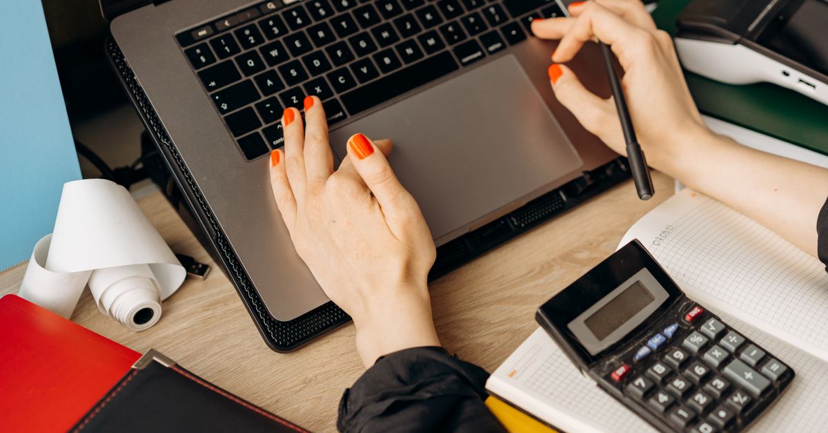 Office worker using a laptop, whose reused passwords feed credential stuffing
