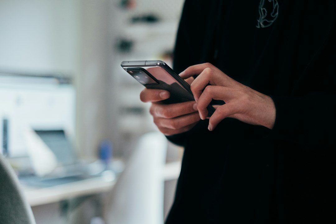 Office worker using a smartphone, the kind of public activity OSINT gathering can draw on