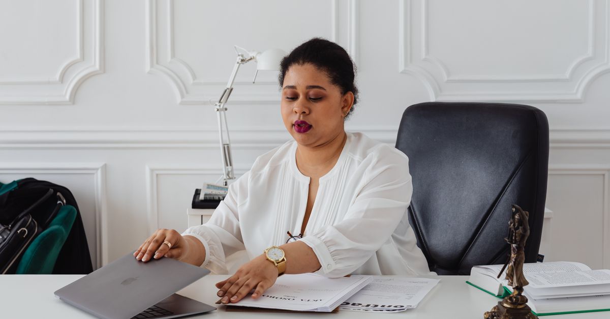 Solicitor at a laptop with client paperwork, the kind of data law firm penetration testing protects